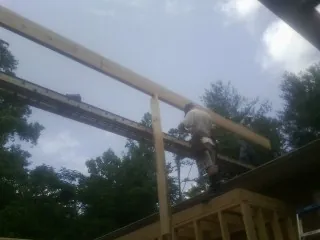 Carpenter setting a ridge beam over a new addition frame — Ice Dam Removal by Roofing Brothers in Snowville