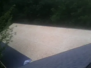 New OSB roof sheathing installed beside an existing shingle roof in Snowville