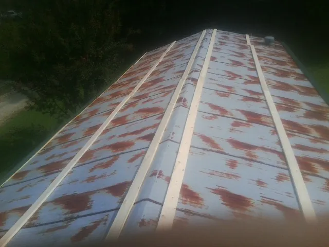 Rusted metal roof panels with new wood purlins before replacement — Storm Damage Roof Repair in Snowville by Roofing Brothers