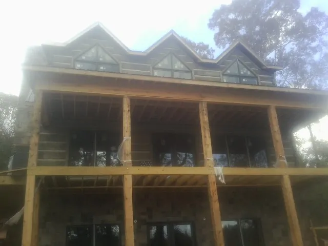 Dormers and porch framing on a large log home under construction — Roof Coating work by our crew in Snowville