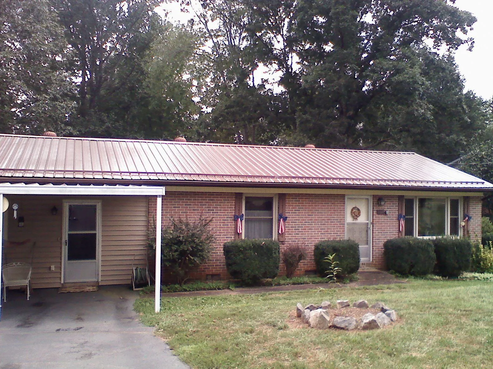 Bronze metal roof and carport on a brick ranch home — Roof Repair work by our crew in Snowville